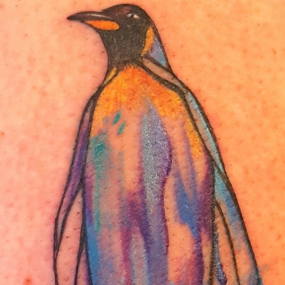 Tattoo of a colorful watercolor-inspired penguin