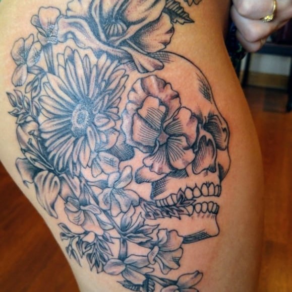 Tattoo of a skull surrounded by flowers