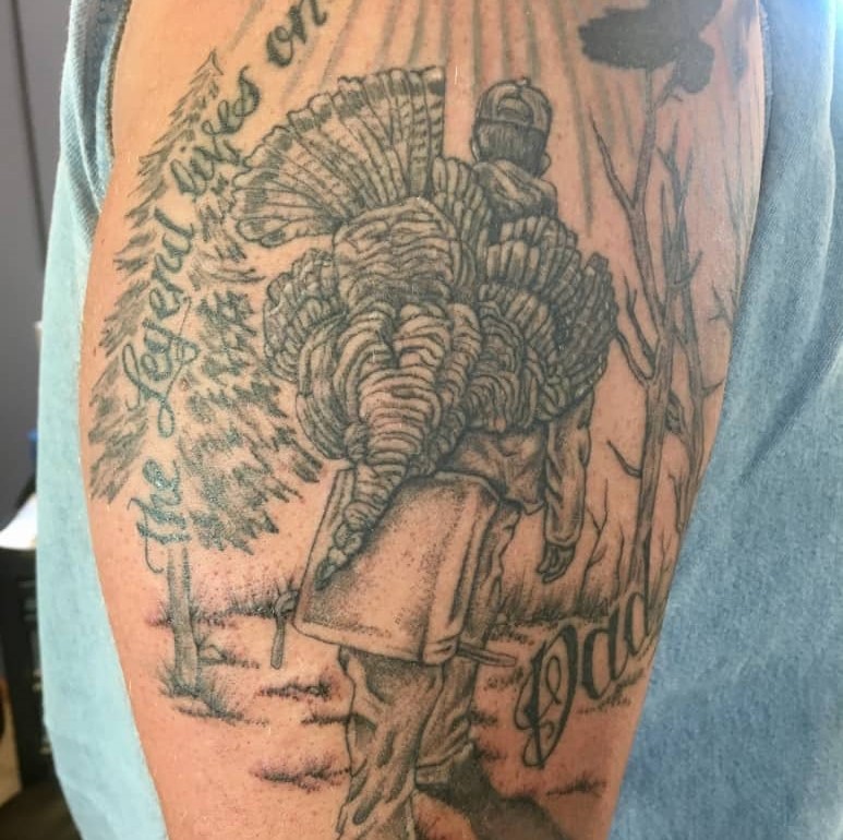 Tattoo of a hunter with a turkey on his back