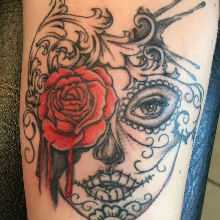Tattoo of a calavera woman with a flower in her eye