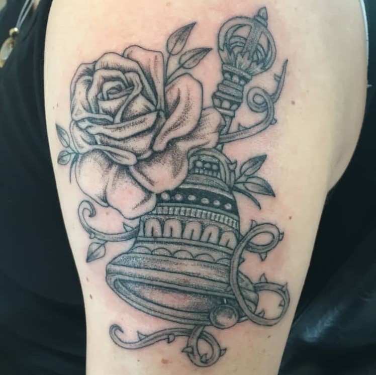 Tattoo of a bell with a flower wrapped around it
